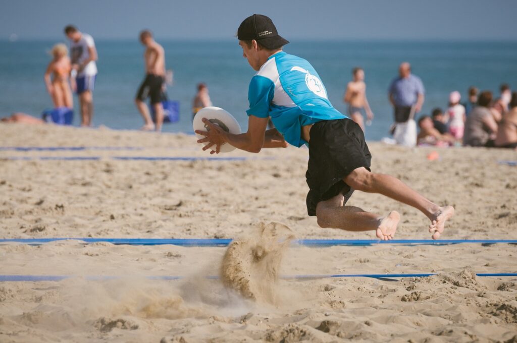 Person training for ultimate frisbee at the beach